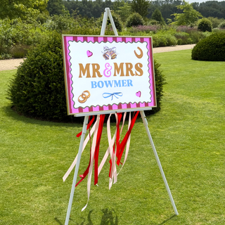Decorative sign for Mr & Mrs Bowmer with ribbons on a grassy background