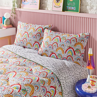 Bedroom with colourful rainbow-patterned bedding and wall art.